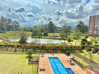 a swimming pool in a park with a body of water at Apartamento con amplia zona de trabajo in Rionegro