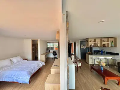 a bedroom and living room with a bed and a kitchen at Apartamento con amplia zona de trabajo in Rionegro