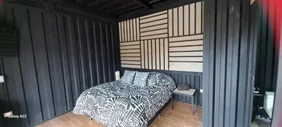 a bedroom with a bed and a striped wall at Cabañas Ecologe BLESS in Chiquinquirá