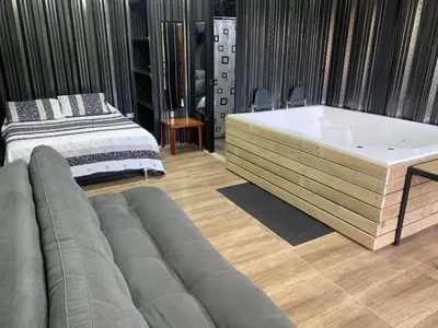 a living room with a tub and a bed at Cabañas Ecologe BLESS in Chiquinquirá