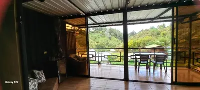 a living room with a view of a table and chairs at Cabañas Ecologe BLESS in Chiquinquirá