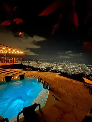 a hot tub at night with a view of a city at LP Finca la Pergola, Naturaleza con Lujo y una increíble vista a todo Medellín in Medellín