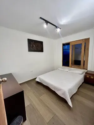 a white bedroom with a bed and a window at LP Finca la Pergola, Naturaleza con Lujo y una increíble vista a todo Medellín in Medellín