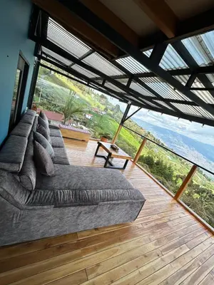 a large couch in a room with a large window at LP Finca la Pergola, Naturaleza con Lujo y una increíble vista a todo Medellín in Medellín