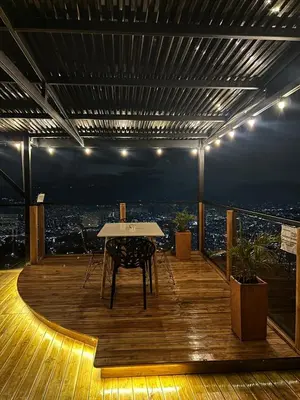 a table on a balcony with a view of a city at LP Finca la Pergola, Naturaleza con Lujo y una increíble vista a todo Medellín in Medellín