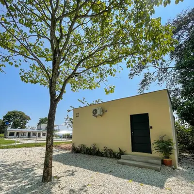 a building with a door and a tree at Cabaña Privada con Jacuzzi en la Hacienda Nápoles in Doradal