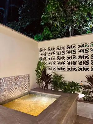a bench in front of a wall with plants at Cabaña Privada con Jacuzzi en la Hacienda Nápoles in Doradal