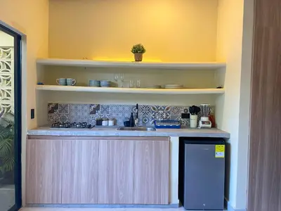 a kitchen with a counter with a sink and a stove at Cabaña Privada con Jacuzzi en la Hacienda Nápoles in Doradal