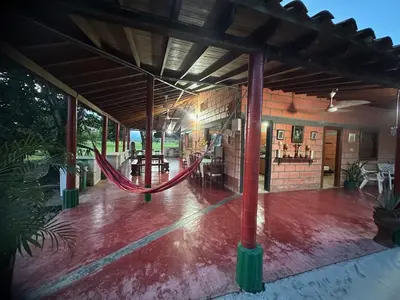 a large room with a hammock in a building at Finca Hotel Ganadera La Bonita in Cantimplora