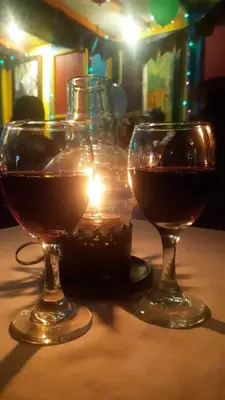 two glasses of wine on a table with a candle at DESCANSO DEL ARRIERO - Su Mejor Descanso en Guatapé in Guatapé