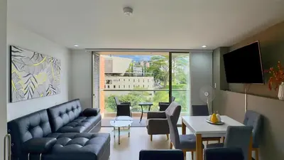 a living room with a couch and a table with chairs at 3BR AC Top Location Views El Poblado in Medellín