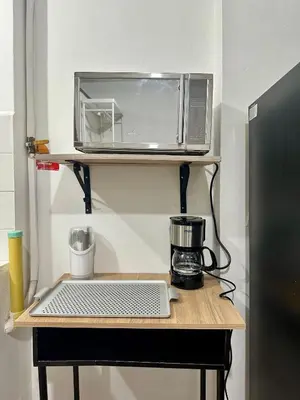a microwave sitting on top of a shelf next to a refrigerator at Cómodo en zona residencial a 1m de Av. el poblado in Envigado