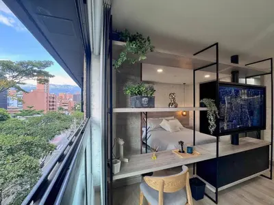 a bedroom with a bed and a balcony with a view at 1BR AC Near Unicentro, UPB & Parques Laureles in Medellín