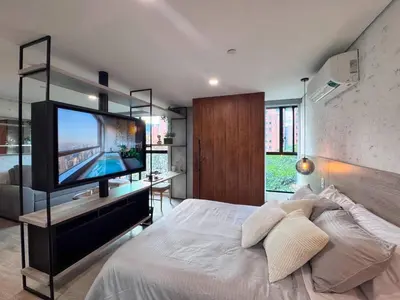 a bedroom with a bed with a flat screen tv at 1BR AC Near Unicentro, UPB & Parques Laureles in Medellín