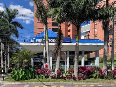 a hotel with palm trees in front of a building at 1BR AC Near Unicentro, UPB & Parques Laureles in Medellín