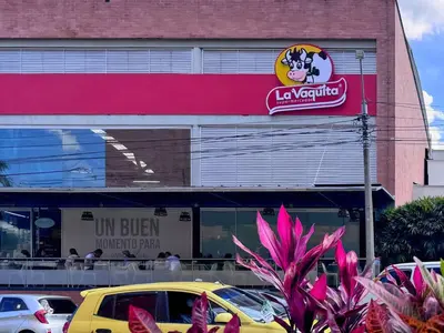 a building with a sign and cars parked in front of it at 1BR AC Near Unicentro, UPB & Parques Laureles in Medellín