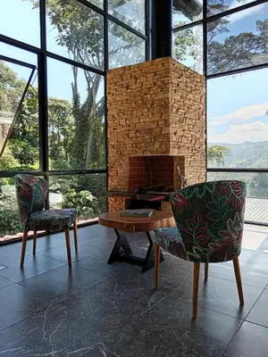 a living room with a fireplace and two chairs at Hospedaje Campestre Providencia in Manizales