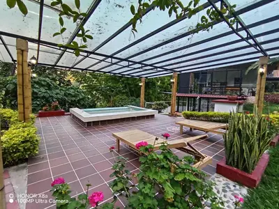 a patio with two picnic tables and a pool at Hospedaje Campestre Providencia in Manizales