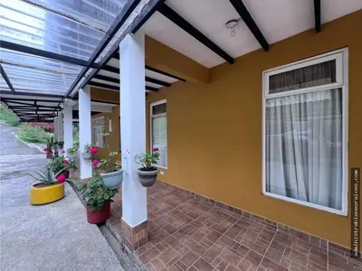 a porch of a house with potted plants on it at Hospedaje Campestre Providencia in Manizales