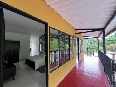 a bedroom with a bed and a balcony at Hospedaje Campestre Providencia in Manizales