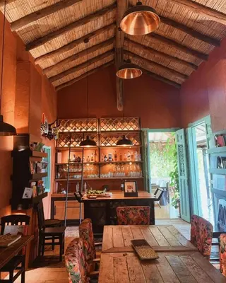 a dining room with a table and chairs and a kitchen at HACIENDA LA SIERRA Finca cafetera de lujo Fredonia in Fredonia
