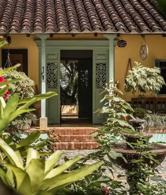 a house with a green door and some plants at HACIENDA LA SIERRA Finca cafetera de lujo Fredonia in Fredonia