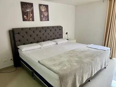 a bedroom with a large bed with white sheets at Luxury 3BR Apartment in the heart of Medellin in Medellín