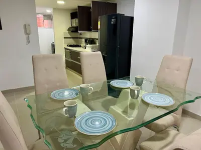 a glass table with three plates on it in a kitchen at Luxury 3BR Apartment in the heart of Medellin in Medellín