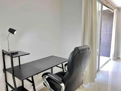 a desk and a chair in a room with a window at Luxury 3BR Apartment in the heart of Medellin in Medellín