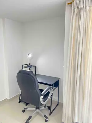 a desk with a chair next to a curtain at Luxury 3BR Apartment in the heart of Medellin in Medellín