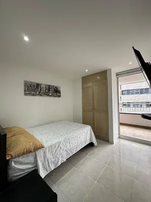 a bedroom with a bed and a large window at Apartamento en el Poblado junto al cc Santa Fe in Medellín
