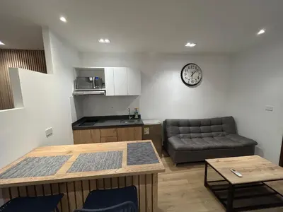 a living room with a couch and a clock on the wall at Lujoso Apartamento a Pasos del Metro de Medellin in Medellín