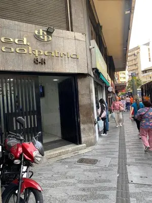 a red scooter parked in front of a store at Lujoso Apartamento a Pasos del Metro de Medellin in Medellín