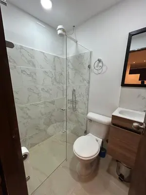 a bathroom with a toilet and a glass shower at Lujoso Apartamento a Pasos del Metro de Medellin in Medellín
