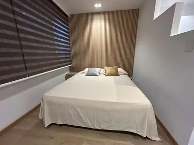 a bedroom with a large bed with two pillows on it at Lujoso Apartamento a Pasos del Metro de Medellin in Medellín