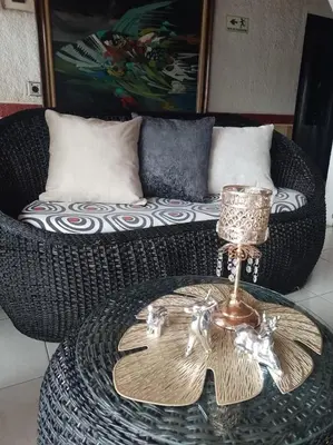 a wicker couch with a glass table with a glass end table with a glass at hotel kerana moon in Puerto Boyacá