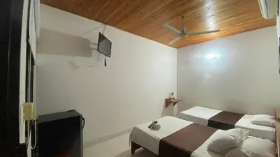 a bedroom with two beds and a television in it at hotel kerana moon in Puerto Boyacá