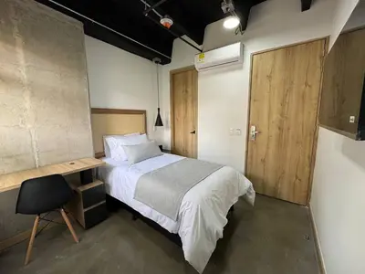 a bedroom with a bed and a desk in it at Akela Park Hotel in Medellín