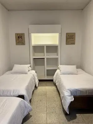 two beds in a room with white sheets at Vivienda turística Casa Rionegro colonial in Rionegro