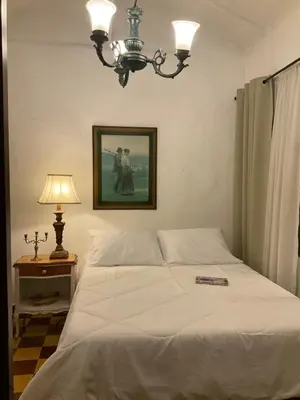 a bedroom with a white bed with a lamp and a picture at Casa Oasis - La Estrella in La Estrella