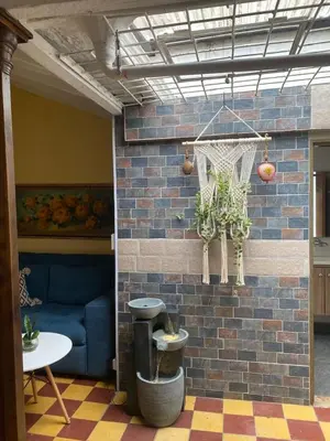 a room with a brick wall and a blue couch at Casa Oasis - La Estrella in La Estrella