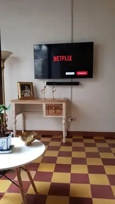 a living room with a television on a wall at Casa Oasis - La Estrella in La Estrella