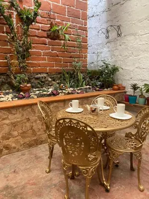 a table and four chairs and a brick wall at Casa Oasis - La Estrella in La Estrella