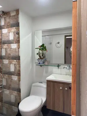 a bathroom with a toilet and a sink and a mirror at Casa Oasis - La Estrella in La Estrella