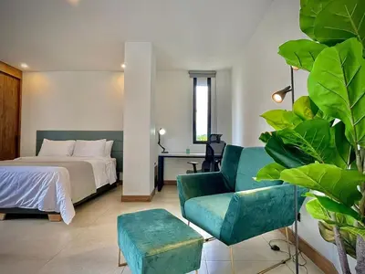 a bedroom with a bed and a couch and a chair at Nice Apartment 205 in san lucas in Medellín