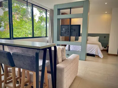 a bedroom with a bed and a table and a couch at Nice Apartment 205 in san lucas in Medellín