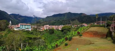 a town on a hill with mountains in the background at habitación campestre para pareja LAVANDA in Jardin
