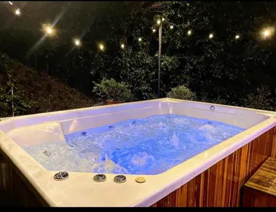 a jacuzzi tub in a backyard at night at Villa cerca al aeropuerto in Guarne