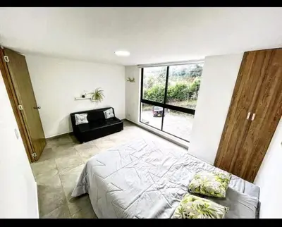 a bedroom with a bed and a large window at Villa cerca al aeropuerto in Guarne