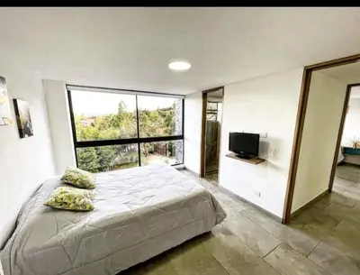 a bedroom with a bed and a large window at Villa cerca al aeropuerto in Guarne